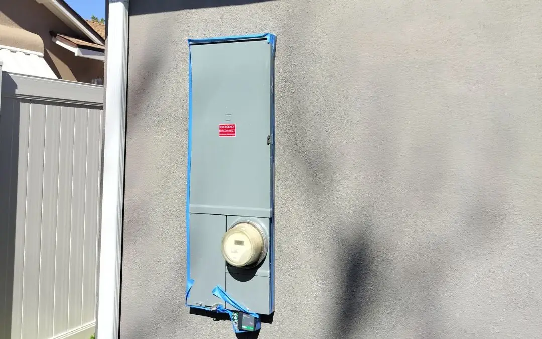 New main electrical panel with meter and emergency disconnect on a stucco wall