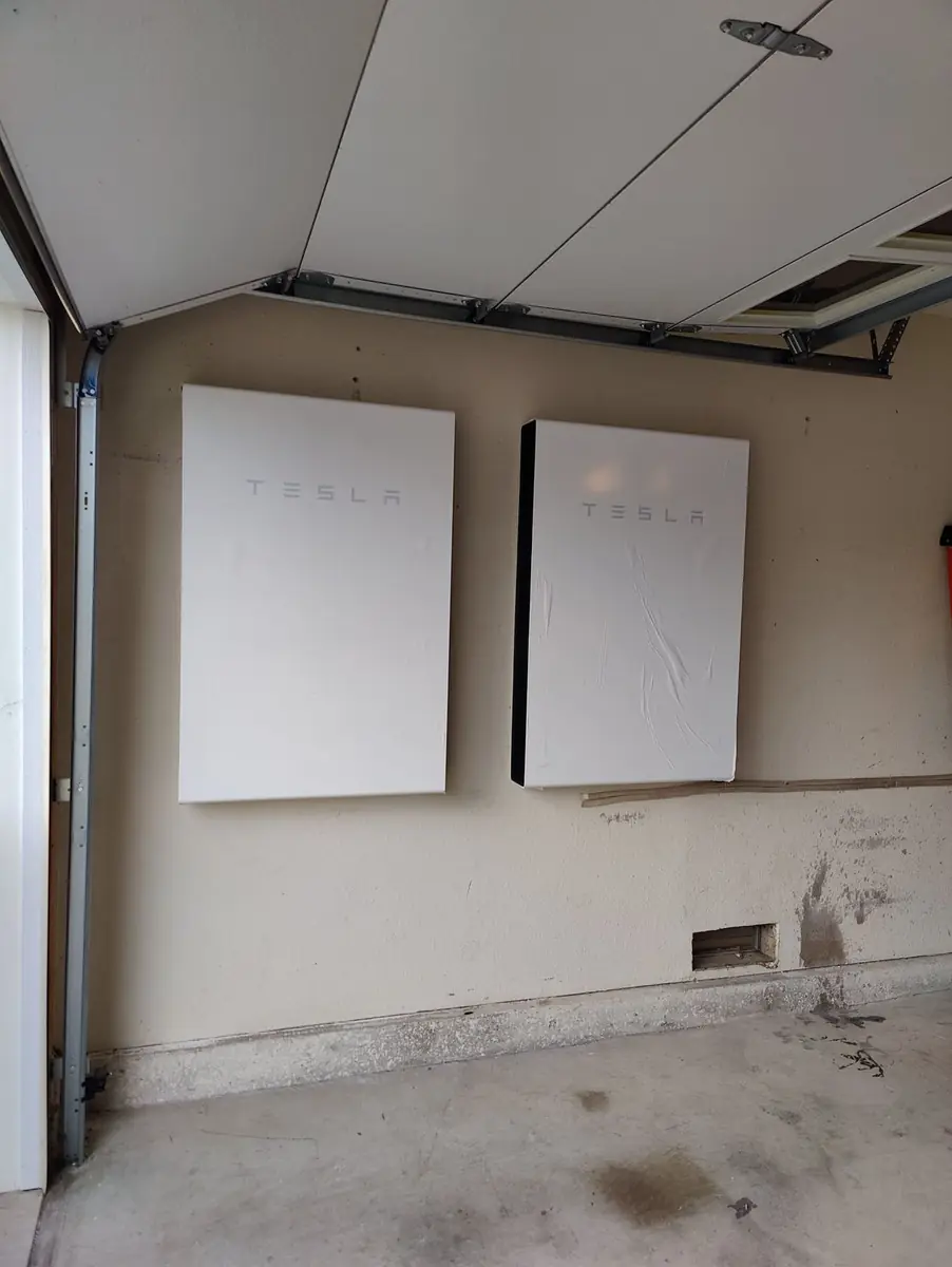 Two Tesla Powerwall batteries mounted in a garage