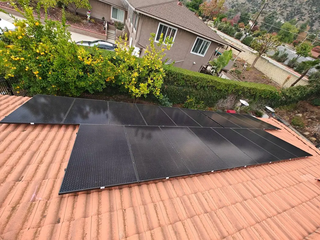Black solar panels on a terracotta tile roof